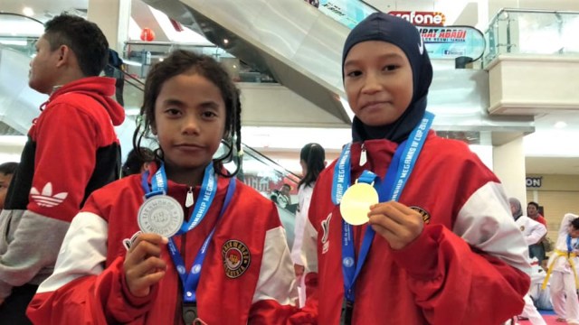Dua pelajar Maluku Utara, atlet taekwondo yakni Dhea Ananda Kadir mendapat medali emas dan Widi Sari M Taher mendapat medali perak di kejuaraan taekwondo di Manado. Mereka berangkat tanpa bantuan pemerintah, menggunakan kapal laut. Foto: Dok istimewa 