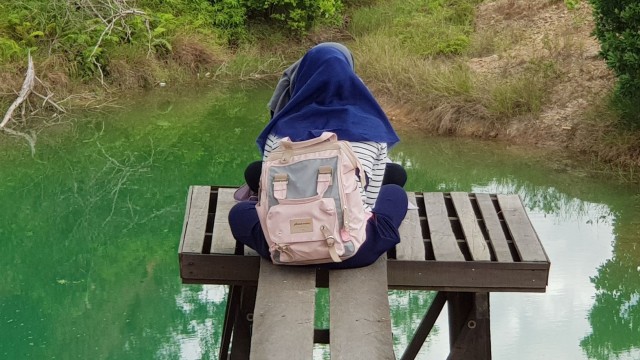 Dua perempuan bercengkrama di Taman Wisata Burung berlatar kolam tambang berair hijau tosca. Foto: Diananta/banjarhits.id