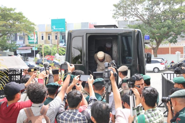 Wartawan mengambil gambar saat pelanggar syariat Islam diturunkan dari mobil untuk dicambuk, Senin (4/3). Foto: Suparta/acehkini