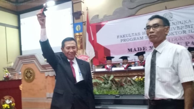 Made Mangku Pastika setelha dinyatakan lolos dalam uji disertasi di Fakultas Hukum UNUD, Senin (4/3) - kanalbali/LSU