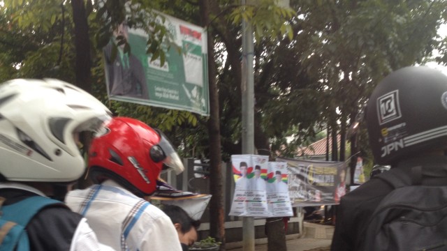 Pengendara melintas di depan atribut kampanye di Jalan Malabar, Bandung. (Iman Herdiana)