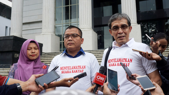 Denny Indrayana (tengah), Titi Annggraini (kiri), dan Hadar Nafis Gumay (kanan) memberikan keteringan kepada wartawan usai mengajukan permohonan pengujian konstitusionalitas UU Nomor 7 tahun 2017 tentang Pemilu ke Mahkamah Konstitusi, Jakarta, Selasa (5/3). Foto: Fanny Kusumawardhani/kumparan