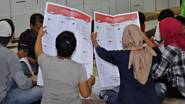 Sejumlah pekerja menyortir dan melipat surat suara di Gedung Eks Bandara Polonia Medan, Sumatera Utara. Foto: Antara/Septianda Perdana