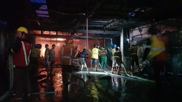 Petugas berusaha memadamkan api yang membakar sebuah gudang beras di Jl M Sohor, Pontianak, Selasa (5/3). Foto: Daddy Cavalero