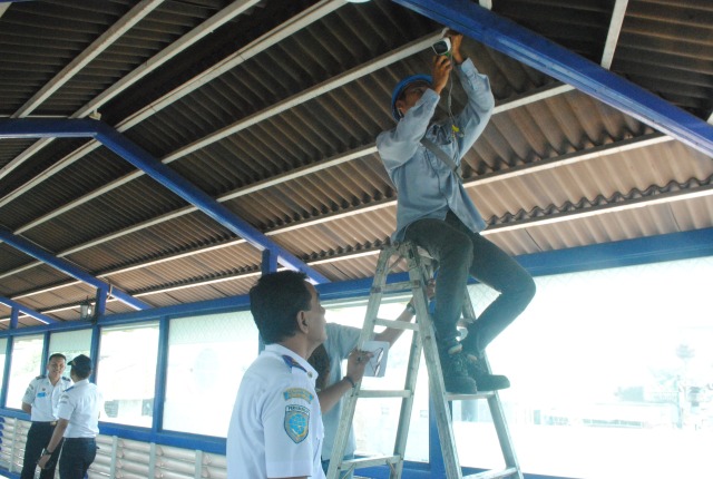 Petugas sedang memasang CCTV di Skybridge yang menghubungkan Stasiun Solo Balapan dan Terminal Tirtonadi pada Selasa (5/3/2019). (Tara Wahyu N.V.)