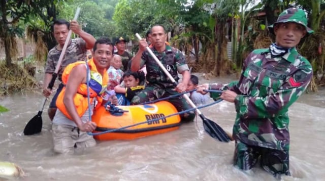 Petugas gabungan mengevakuasi warga terdampak banjir di Madiun