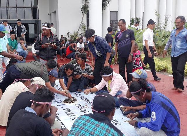 Para nelayan Kepri memrotes aktivitas reklamasi yang merugikan mereka dengan cara membakar ikan di Kantor Gubernur Kepri. (Foto: Yogi/batamnews)