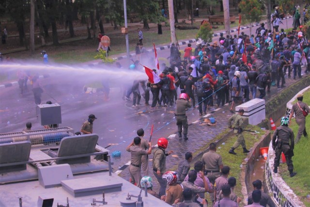 Aparat Kepolisian saat menembakkan air menggunakan water canon untuk membubarkan masa aksi, Rabu (5/3). Foto: Mufti