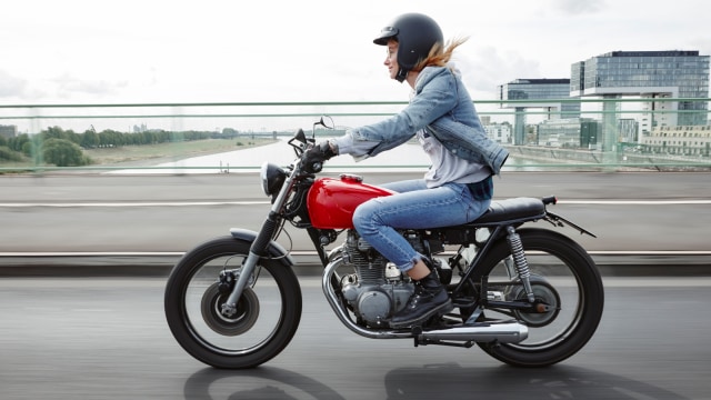 Ilustrasi perempuan mengendarai sepeda motor. Foto: Getty Images