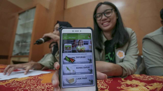 Seorang mahasiswi Universitas Gadjah Mada (UGM) Yogyakarta menunjukan aplikasi OkeSayur. Foto: Dok. Humas UGM