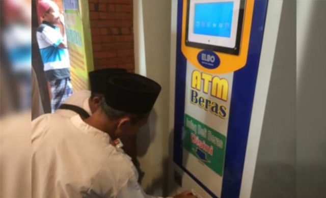 Salah satu warga saat mencoba mengambil beras di mesin ATM di Masjid Al-Khalid Kelurahan Semampir, Kota Kediri.