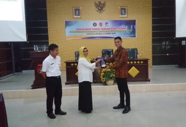 Plt. Asisten Administrasi Umum, Aida Lailawati bersama Kadiskominfo, Rody Iskandar, saat menerima plakat dari perwakilan BSrE, Agung Nugraha di Aula Bappeda Kobar baru-baru ini (Foto: Diskominfo Kobar)