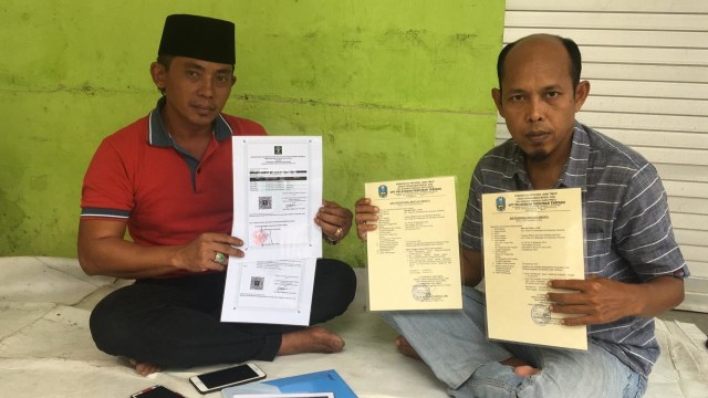 Kepala SMK Miftahul Ulum Junaidin (kanan) didampingi aktivis Lira Sampang Nur Hasan (kiri) menunjukkan legalitas sekolah, Jumat (8/3/2019). (Ryan Hariyanto/MM).