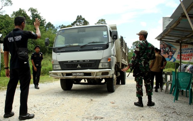 Petugas memeriksa kendaraan yang melintas batas negara di Pos Jagoi Babang, Kabupaten Bengkayang, Kalimantan Barat. Foto: Herman SP
