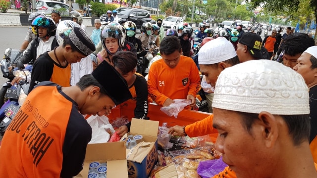 Relawan asal BPK Darul Fitrah membagikan paket makanan-minuman gratis ke jemaah haul Guru Sekumpul di Jalan Ahmad Yani Km 5, Kota Banjarmasin, Minggu (10/3/2019). Foto: Diananta/banjarhits.id