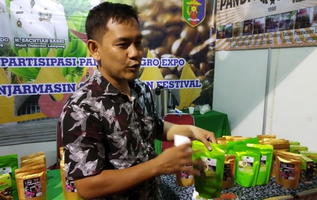Putra, penjaga stan pamer Pemprov Lampung menunjukkan kopi asli Lampung. Foto: Zahidi/banjarhits.id
