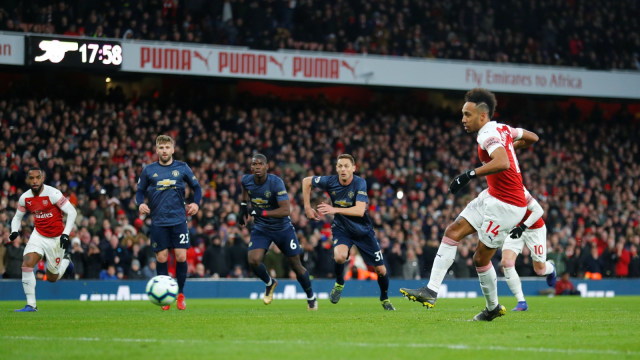 Pierre-Emerick Aubameyang mencetak gol penalti untuk Arsenal saat menghadapi Manchester United. Foto: Eddie Keogh/Reuters