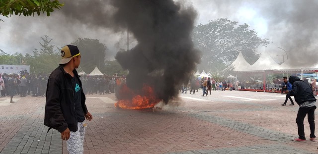 Suasana para aksi saat membakar ban di acara Kongres Korban Bencana Pasigala di lapangan Vatulemo, Jalan Balai Kota Palu, Senin (11/3). Foto: Tim PaluPoso