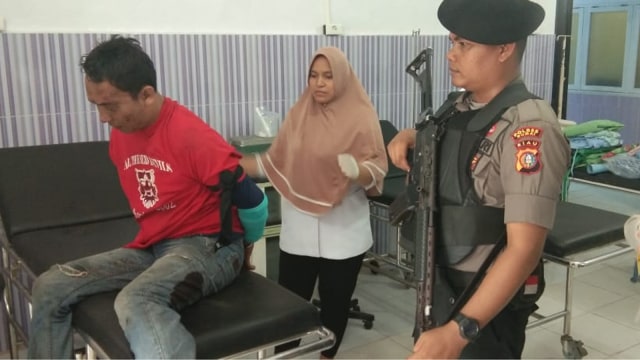 MARGONO, warga diduga hendak merampok Bank BNI Cabang Dumai, Jalan Sudirman, Senin, 11 Maret 2019, pukul 09.30 WIB, saat menjalani pengobatan di rumahg sakit terdekat dengan pengawalan polisi lengkap dengan laras panjangnya. (Foto: ISTIMEWA)