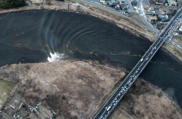 Gelombang pasang tsunami  di sungai Naka, kota Hitachinaka, prefektur Ibaraki, Jepang. Foto: AFP PHOTO / JIJI PRESS