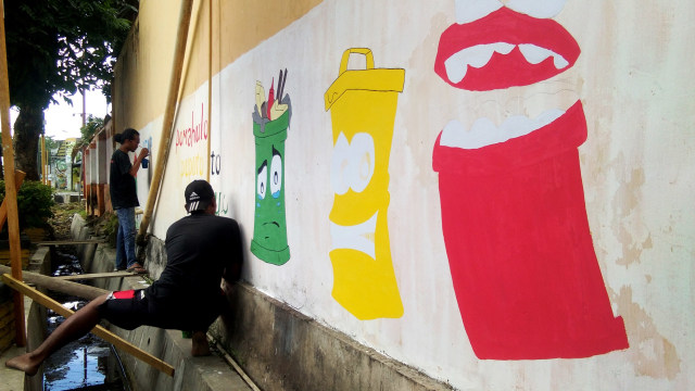 Warga Kelurahan Paguyaman, Kota Tengah, Kota Gorontalo saat membuat mural di sepanjang tembok jalan Selayar sebagai kampanye peduli sampah. Senin (11/3) Foto : Rahmat Ali