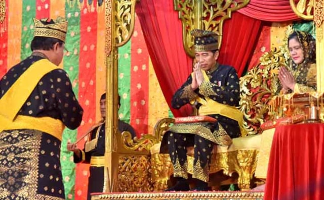 PRESIDEN Joko Widodo saat menjalani prosesi pemberian gelar adat oleh Lembaga Adat Melayu Riau (LAMR), Sabtu, 15 Desember 2018.  