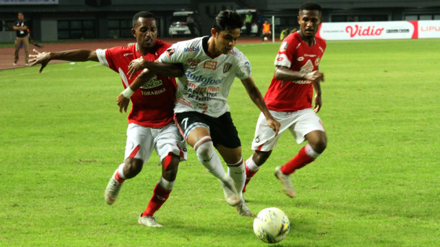Pemain Semen Padang, Boas Atururi (kiri), membayangi pemain Bali United, Miftahul Hamdi. Foto: Antara/Risky Andrianto