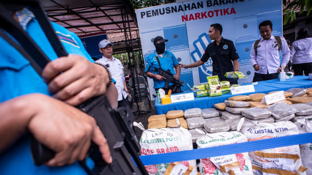Petugas BNN beraktivitas di dekat barang bukti saat rilis pemusnahan barang bukti narkotika, di Badan Narkotika Nasional (BNN), Jakarta, Selasa (12/3). Foto: ANTARA FOTO/Aprillio Akbar