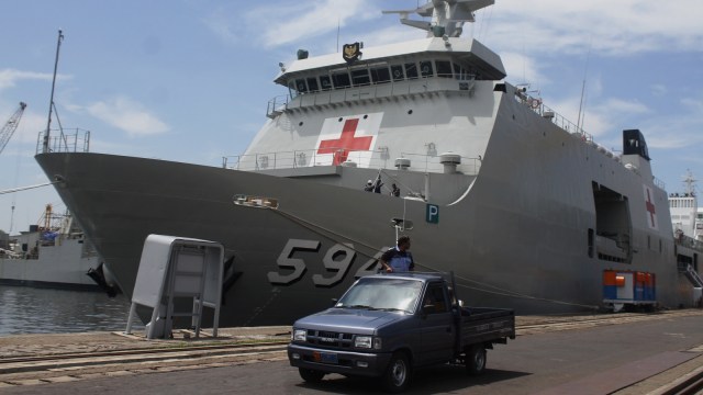 Sebuah mobil melintas di samping KRI Semarang 594 sebelum berlayar di Dermaga PT PAL, Surabaya, Jawa Timur, Rabu (13/3). Foto: ANTARA FOTO/Ari Bowo Sucipto