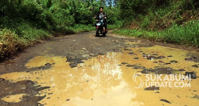Jalan penghubung tiga desa di Kecamatan Purabaya rusak. Jalan rusak berupa lubang besar yang digenangi air. | Sumber Foto:Demmi Pratama