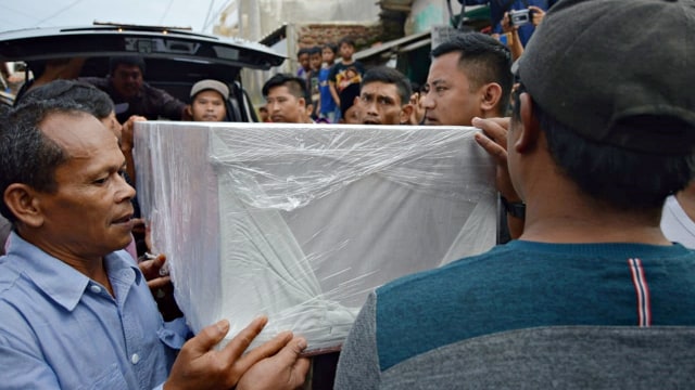 Sejumlah kerabat dibantu petugas mengangkat peti korban mutilasi di Malaysia, Nuryanto, saat tiba di kediamannya, di Kabupaten Bandung. Foto: Okky Ardiansyah/kumparan