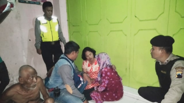 Seorang ibu rumah tangga yang mencoba bunuh diri ditenangkan oleh petugas dan warga. (foto: fajar eko nugroho)