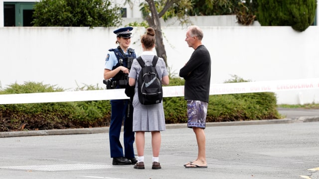 Petugas polisi sedang berbicara kepada warga di dekat masjid Masjid al Noor usai insiden penembakan di Christchurch, Selandia Baru. Foto: AFP/Tessa BURROWS