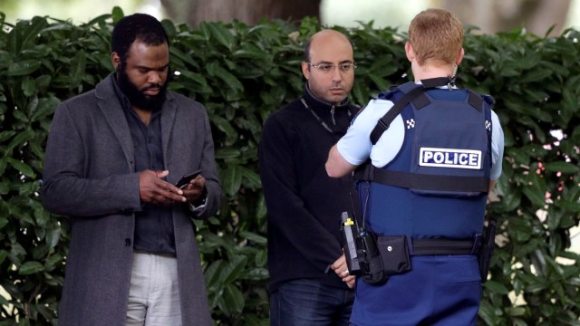 Seorang petugas polisi sedang berbicara dengan sejumlah saksi di dekat masjid di Christchurch, Selandia Baru. Foto: AP Photo/Mark Baker