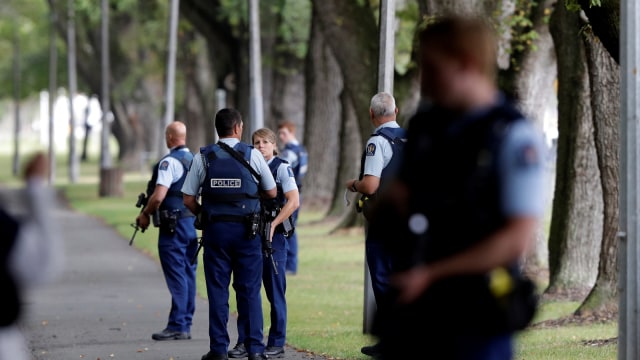 Polisi sedang berjaga-jaga di sebuah taman di seberang jalan dari masjid, Christchurch, Selandia Baru. Foto: AP Photo/Mark Baker