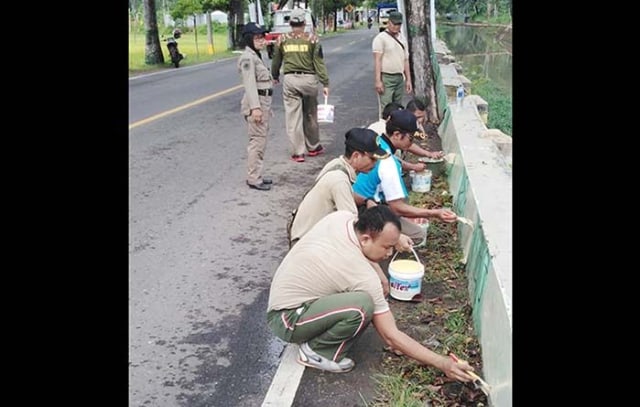 Para personil TNI-Satpol PP saat melakukan aksi bersihkan vandalisme.