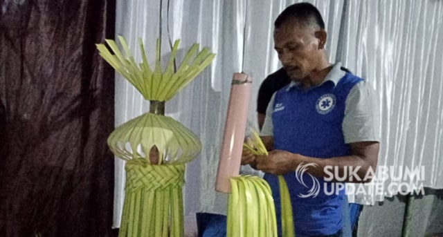 Obar Subandi (42 tahun), warga Cikembar, Kabupaten Sukabumi, sedang menyelesaikan pembuatan sebuah janur kuning. | Sumber Foto:Ruslan AG.