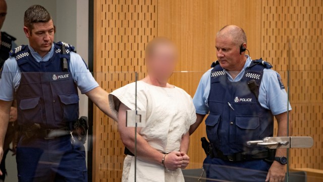 Brenton Tarrant, didakwa atas pembunuhan terkait serangan masjid di bawa oleh petugas ke kursi pesakitan pengadilan distrik Christchurch, Selandia Baru. Foto: Reuters