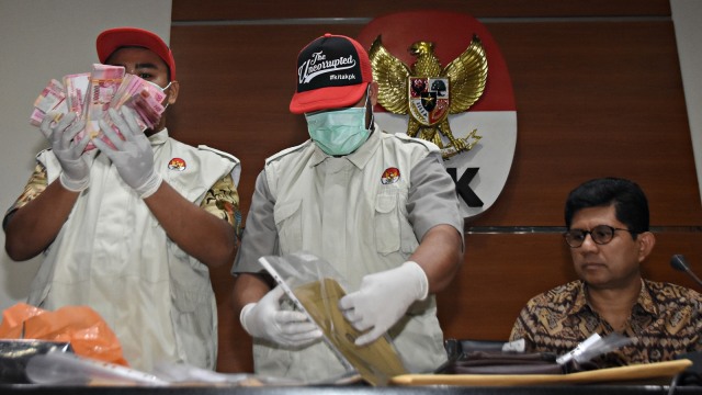 Wakil Ketua KPK Laode M. Syarief bersama penyidik menunjukkan barang bukti hasil OTT kasus dugaan suap Ketua Umum PPP Romahurmuziy saat konferensi pers di gedung KPK, Jakarta. Foto: Antara/Indrianto Eko Suwarso