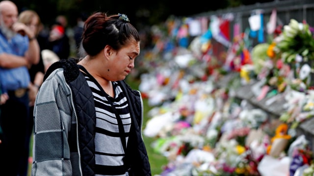 Seorang wanita menangis di area penghormatan bunga di Botanical Gardens, Christchurch, Selandia Baru. Foto: Reuters/Edgar Su