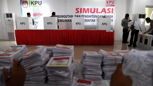 Sejumlah penyelenggara Pemilu 2019 melakukan pencoblosan kertas suara di bilik suara saat simulasi pemungutan dan perhitungan suara pemilihan umum 2019 di Sumenep, Jawa Timur, Sabtu (16/3). Foto: ANTARA FOTO/Zabur Karuru