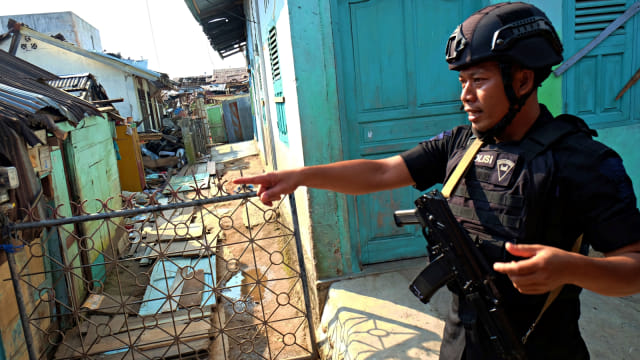 Personel Brimob berjaga di dekat lokasi rumah terduga teroris dan juga rumah warga yang rusak akibat ledakan bom bunuh diri di Kecamatan Sibolga Sambas, Sibolga, Sumatera Utara. Foto: Antara/Irsan Mulyadi