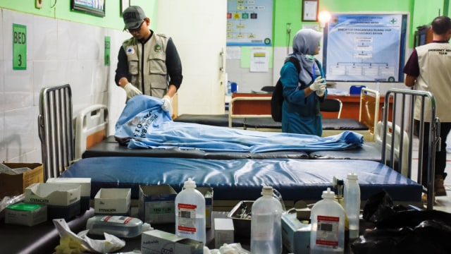 Petugas medis memerika kondisi korban meninggal dunia tertimbun longsor akibat gempa bumi, Tai Sieu Kim (56) asal Malaysia di Puskesmas Bayan, Tanjung, Lombok Utara, NTB, Minggu (17/3/2019). Foto: ANTARA FOTO/Ahmad Subaidi