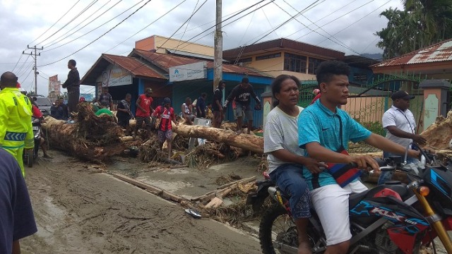 Material banjir yang masih berada di sisi badan jalan Sentani. (BumiPapua.com/Katharina) 