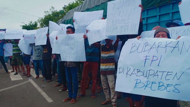 Massa membentangkan poster penolakan terhadap organisasi Front Pembela Islam (FPI) di Brebes, Senin (18/3). (Foto: Fajar Eko Nugroho)