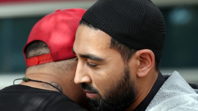 Pelukan sebagai dukungan dan penghormatan dari anggota geng motor di Selandia Baru, Mongrel Mob (bertopi merah), untuk umat Islam dan para keluarga korban tragedi Christchurch. Foto: AFP/MICHAEL BRADLEY