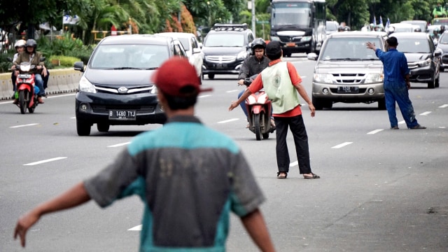 Pekerja menawarkan jasa poles body mobil di sekitar JPO Kramat Sentiong, Jalan Kramat Raya, Senen, Jakarta Pusat. Foto: Jamal Ramadhan/kumparan