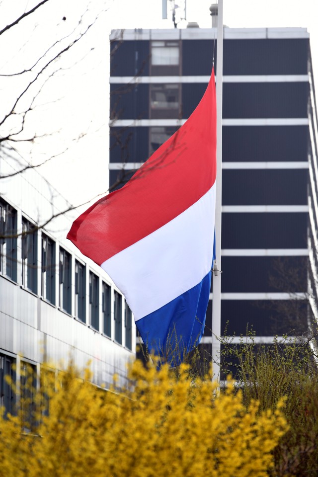 Bendera nasional dikibarkan setengah tiang di dekat lokasi penembakan di Utrecht, Belanda. Foto: REUTERS/Piroschka van de Wouw
