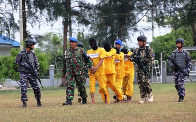 TNI menggiring empat kurir sabu yang ditangkap di Markas Lanal Lhokseumawe, Selasa (19/3). Foto: Agust 