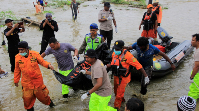 TIm SAR Gabungan mengangkat kontong korban banjir bandang Sentani yang ditemukan di sekitar perumahan Gajah Mada Sentani Jayapura, Papua, Selasa (19/3). Foto: ANTARA FOTO/Gusti Tanati